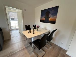 a dining room with a table with chairs and a picture at Seaside-Amrum-11 in Norddorf