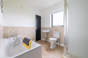 une salle de bain avec une baignoire, des toilettes et un lavabo dans l'établissement Foyle View Retreat, à New Buildings 57 autres photos