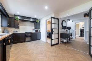 une cuisine avec des armoires noires et un plancher en bois dans l'établissement Foyle View Retreat, à New Buildings