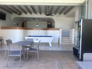 a room with a table and a bath tub at Bright Ocean Horizon Escape in Noosa Heads