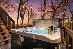 einen Whirlpool auf einer Terrasse mit einer Flasche Wein in der Unterkunft The Fox & Fir Luxe Retreat- Sauna & Cold Plunge in Blue Ridge