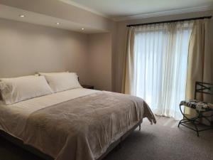 a bedroom with a bed and a large window at Hotel Colonos Los Angeles in Los Ángeles