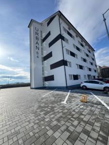 Un edificio con un coche aparcado en un estacionamiento. en Modern Nest By David, en Sibiu