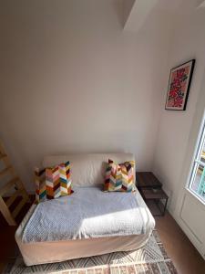 un lit dans une chambre avec deux oreillers dessus dans l'établissement The cozy corner of Amelie, à Nice