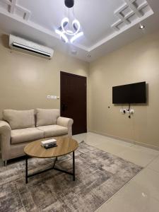a living room with a couch and a tv at سويت غرفتين وصالة مميز in Jeddah