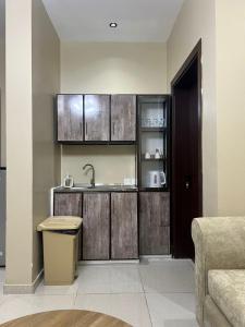 a kitchen with wooden cabinets and a sink at سويت غرفتين وصالة مميز in Jeddah +13 photos
