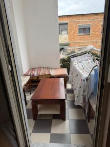 - un petit balcon avec une table et un banc dans l'établissement Urban Apartment, à Tirana