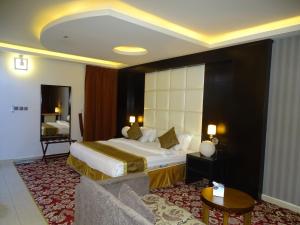 a hotel room with a bed and a chair at زيفل للشقق المخدومة in Buraydah
