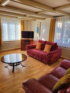 a living room with a red couch and a coffee table at Chalet Lilo Big View in Beatenberg