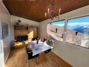a dining room with a table and chairs and a window at Chalet Lilo Big View in Beatenberg