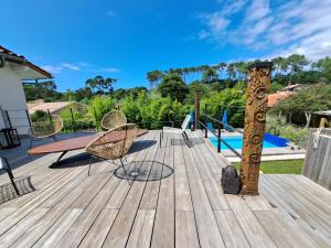 a wooden deck with chairs and a wooden pole at Villa Hossegor - 4 étoiles, 6 chambres - 5 salles de bains - piscine chauffée 5 mn des plages in Hossegor