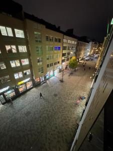 una calle vacía por la noche con gente caminando en Modern Studio Apt in Design District, en Helsinki