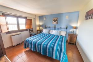 a bedroom with a bed with a striped blanket at Casa El Pino Azul, Ferienhaus Für 2 4 Personen in Dúrcal