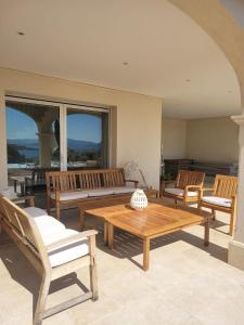 a living room with benches and a table and chairs at La Villa in Sainte-Maxime