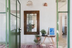 Cette chambre dispose d'un miroir et d'une table avec des plantes. dans l'établissement הבית האנדלוסי, à H̱aẕeva