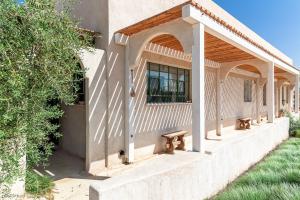 ein Gebäude mit einer Bank an der Seite in der Unterkunft הבית האנדלוסי in H̱aẕeva