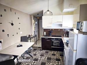 a kitchen with a table and a white refrigerator at La maisonnette de Pizancon in Chatuzange-le-Goubet