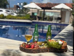 a tray of food and two bottles of wine and a glass at Makambira Residence no Centro de Porto de Galinhas in Porto De Galinhas