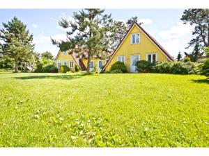 una casa gialla in cima a un campo d'erba di Ferienhof Ebsen a Langenhorn