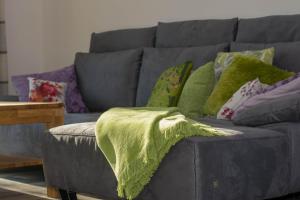 a gray couch with colorful pillows on it at Ferienhaus In Niebüll Mit Großer Terrasse in Niebüll