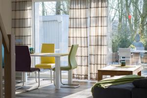 a room with a table and chairs and a window at Ferienhaus In Niebüll Mit Großer Terrasse in Niebüll +8 photos