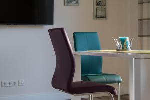 a dining room table with two blue chairs and a table with at Ferienhaus In Niebüll Mit Großer Terrasse in Niebüll