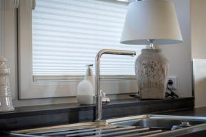 a kitchen sink with a lamp next to a window at Ferienhaus In Niebüll Mit Großer Terrasse in Niebüll