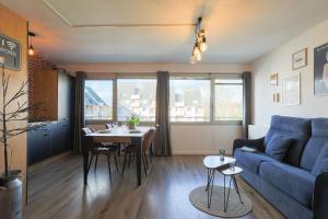 a living room with a blue couch and a table at Appartement magnifique à Paimpol in Paimpol