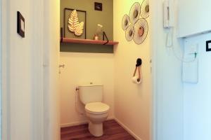a bathroom with a toilet and a shelf on the wall at Appartement magnifique à Paimpol in Paimpol +17 photos
