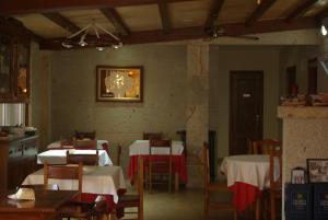 un comedor con mesas y sillas y un reloj en la pared en Casa Mariñeira Lourdes, en Cambados