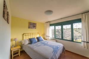 a bedroom with a bed and a large window at Casa El Limonero, Landhaus Mit Aussicht in Dúrcal