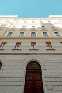 a tall building with a wooden door and an arch at Palazzo Panfilli Central Luxury in Trieste