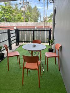 un patio avec une table et des chaises sur l'herbe dans l'établissement Cozy 1-Bedroom apartment, à Ban Lum Fuang