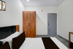SurūrnagarTownhouse Oak L B Nagar Metro Station的卧室里有一张白色的床和一扇木门