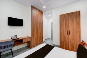 SurūrnagarTownhouse Oak L B Nagar Metro Station的一间卧室，里面有一张床、一张桌子和一台电视。
