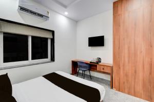 SurūrnagarTownhouse Oak L B Nagar Metro Station的一间卧室，配有一张床、一张书桌和一扇窗户