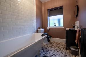 une salle de bain avec baignoire et toilettes et une fenêtre dans l'établissement Beach Bungalow, à Pakefield 43 autres photos