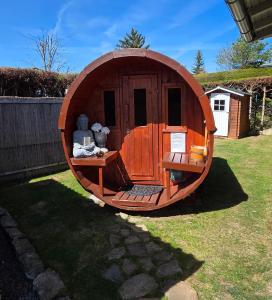 eine kleine hölzerne Hundehütte in einem Hof in der Unterkunft Ferienhaus Sonnenhuesli mit Sauna und Whirlpool auch Hunde sind herzlich willkommen in Lenzkirch + 12 Fotos