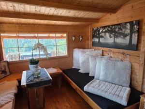 ein Zimmer mit Sofa und Kissen in einer Blockhütte in der Unterkunft Ferienhaus Sonnenhuesli mit Sauna und Whirlpool auch Hunde sind herzlich willkommen in Lenzkirch