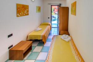 a room with two beds and a table in it at Residence Oasi Anfiteatro in Porto Ottiolu +47 photos
