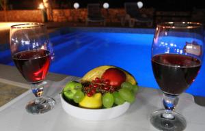 deux verres de vin et un bol de fruits sur une table dans l'établissement Geräumige Ferienvilla Mit Pool Und Meerblick, à Grohote 25 autres photos