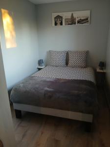 une chambre avec un lit dans une pièce dans l'établissement La Cabane du bois l'abbé, à Saint-Martin-Boulogne