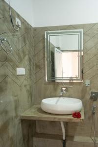 a bathroom with a white sink and a mirror at Taprobana Island Bliss in Dickwella