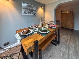 a dining room with a wooden table with wine glasses at The Miners House in Deal