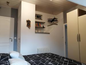 - une chambre avec un lit et un mur avec des étagères dans l'établissement Chambre D'hôtes Les Jonquilles -, à Froberville