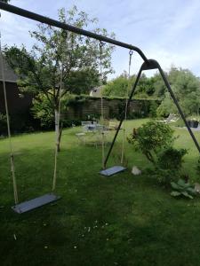 une balançoire vide dans une cour dans l'établissement Chambre D'hôtes Les Jonquilles -, à Froberville