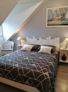 une chambre avec un lit avec une couette noire et blanche dans l'établissement Chambre D'hôtes Les Jonquilles -, à Froberville