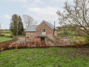 a brick house in the middle of a field at Velindra Farm Cottage in Hereford