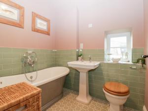 a bathroom with a tub and a toilet and a sink at Velindra Farm Cottage in Hereford +24 photos