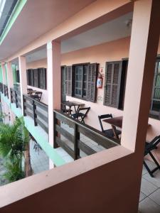 a balcony of a hotel with tables and chairs at Pousada Terranova in Garopaba